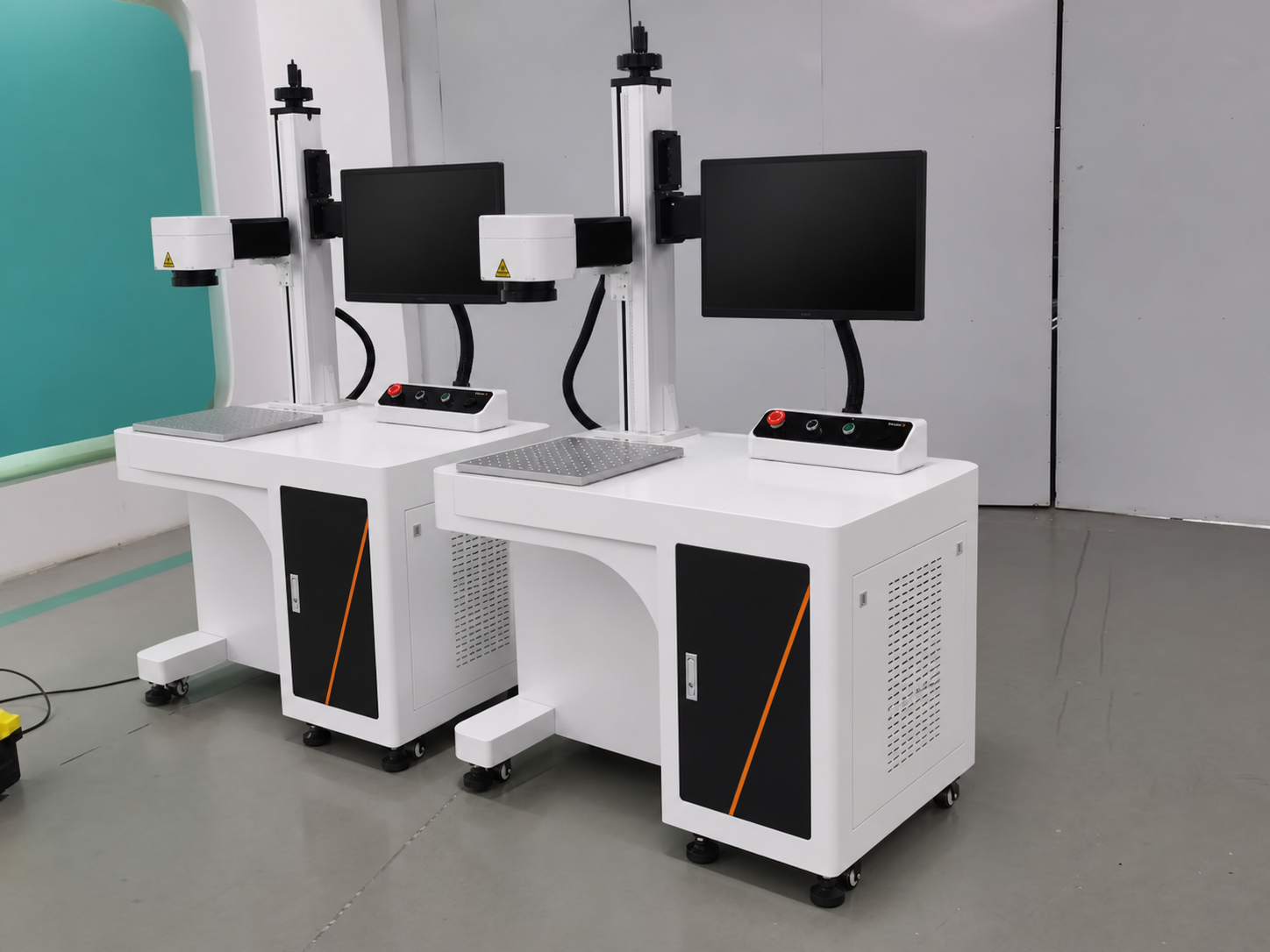 Two desktop laser marking machines in a workshop